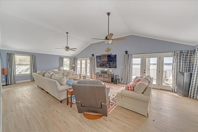 living area featuring lofted ceiling, light wood-style flooring, a ceiling fan, and french doors