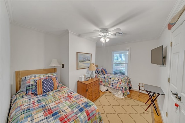 bedroom featuring visible vents, crown molding, light wood finished floors, and ceiling fan