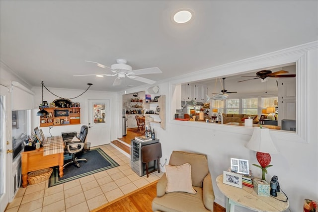 office space featuring ceiling fan, light tile patterned flooring, and crown molding