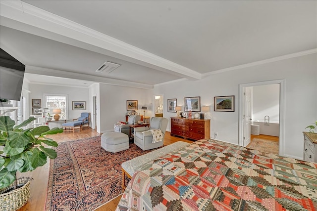 bedroom with beam ceiling, visible vents, crown molding, and wood finished floors