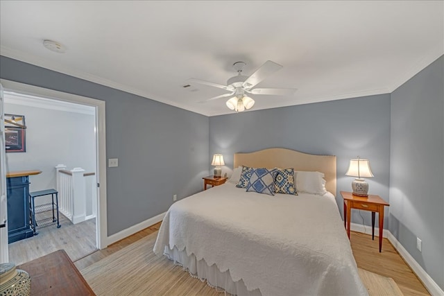 bedroom featuring light wood finished floors, baseboards, a ceiling fan, and ornamental molding