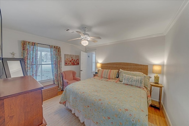 bedroom with visible vents, ornamental molding, light wood-style flooring, and baseboards