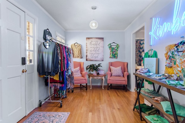 entryway with ornamental molding and light hardwood / wood-style floors