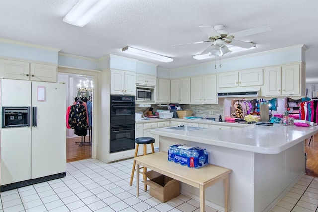 kitchen with kitchen peninsula, crown molding, white appliances, a textured ceiling, and a breakfast bar