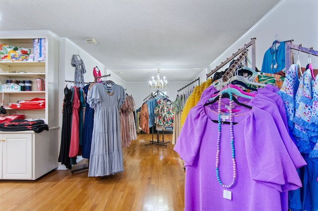 walk in closet featuring light hardwood / wood-style flooring and a notable chandelier