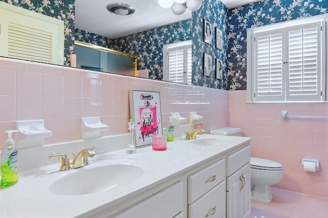 bathroom featuring toilet, tile walls, and vanity