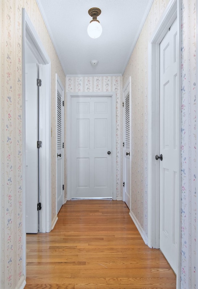 hall featuring light hardwood / wood-style flooring and crown molding