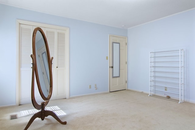 unfurnished bedroom with light colored carpet and crown molding