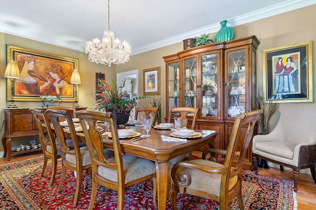 dining area with crown molding, hardwood / wood-style floors, and a notable chandelier