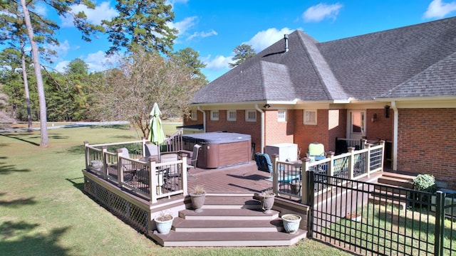 wooden deck with a lawn and a hot tub