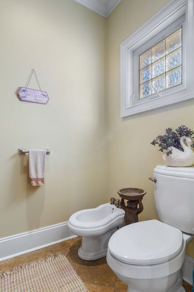 bathroom featuring tile patterned floors, toilet, ornamental molding, and a bidet