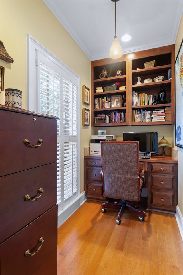 office area featuring light hardwood / wood-style floors, built in shelves, and crown molding