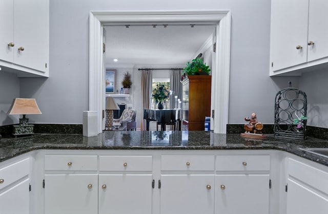 kitchen featuring white cabinets and dark stone countertops