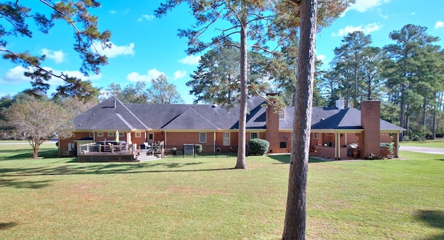 back of house featuring a deck and a lawn