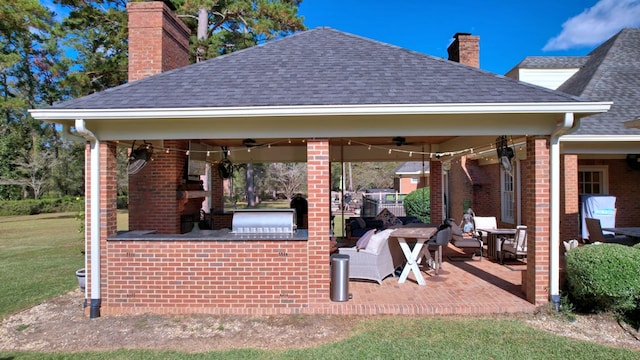 view of patio featuring ceiling fan, a gazebo, and exterior kitchen