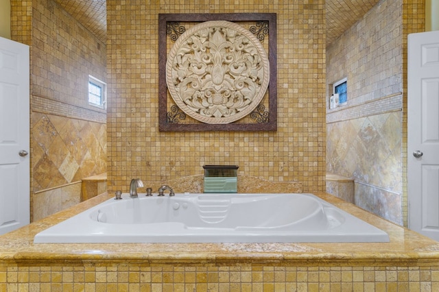 bathroom with tile walls and a relaxing tiled tub