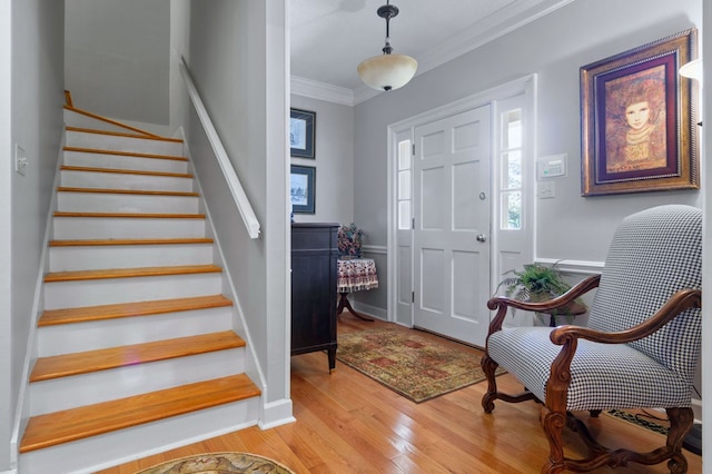 entryway with light hardwood / wood-style floors and ornamental molding