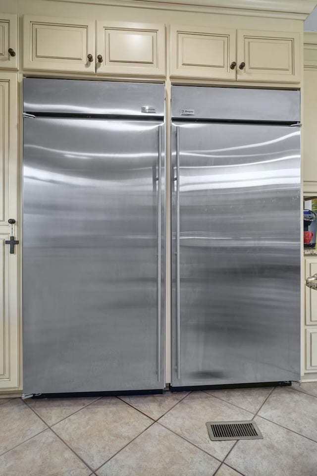 kitchen featuring light tile patterned floors, stainless steel built in refrigerator, and cream cabinets