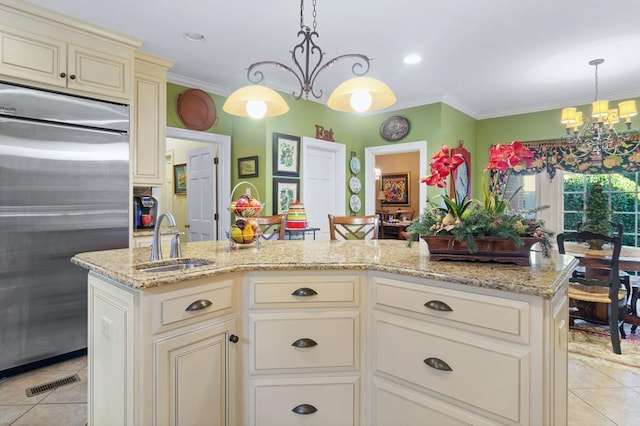 kitchen featuring stainless steel built in fridge, sink, cream cabinets, a kitchen island, and an inviting chandelier