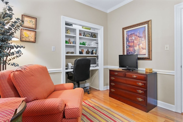 office space with built in shelves, light hardwood / wood-style flooring, and crown molding