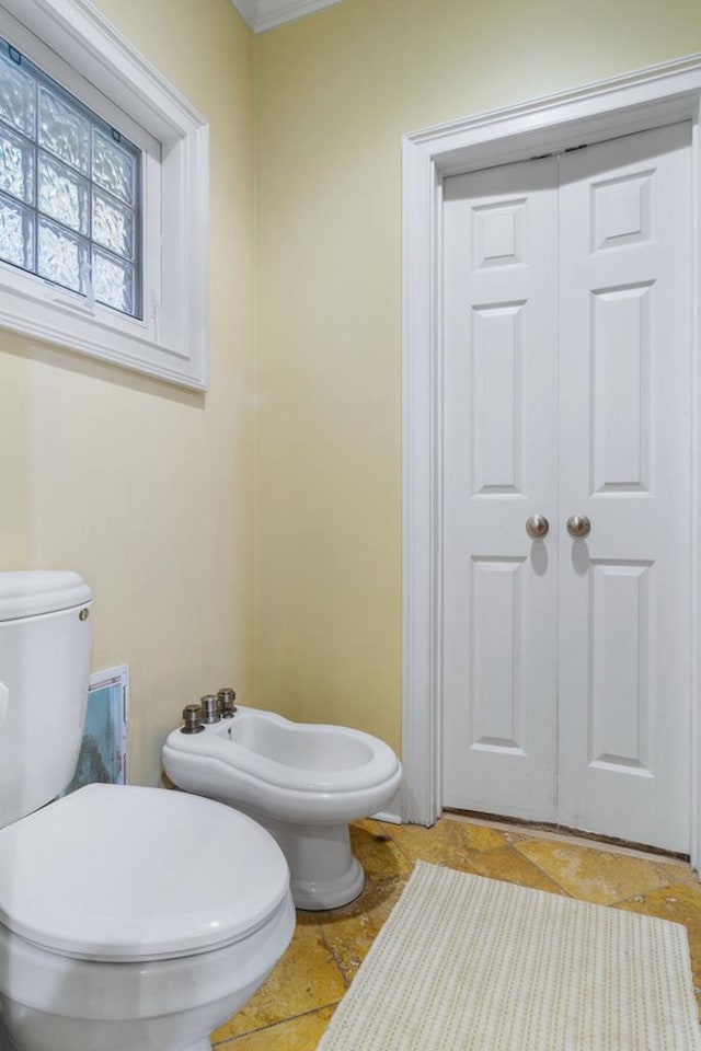 bathroom featuring a bidet, ornamental molding, and toilet