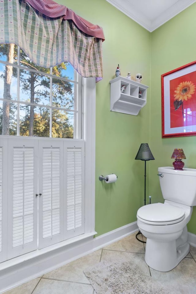 bathroom featuring tile patterned floors, toilet, and ornamental molding