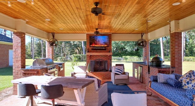 view of patio / terrace featuring grilling area, an outdoor brick fireplace, exterior kitchen, and sink