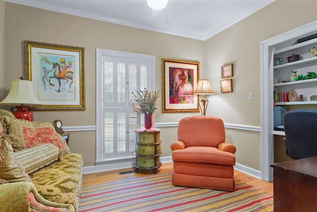 living area with crown molding and light hardwood / wood-style floors