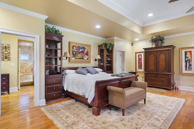 bedroom featuring crown molding, light hardwood / wood-style flooring, and ensuite bath