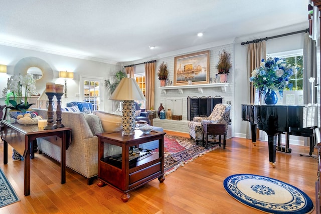 living room with hardwood / wood-style flooring, crown molding, and a fireplace