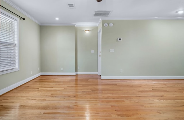 spare room with ornamental molding and light wood-type flooring