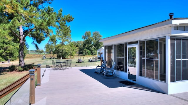 wooden deck with a sunroom and a yard