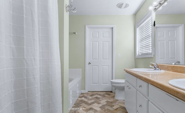 bathroom featuring a tub, toilet, and vanity