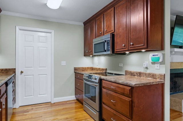 kitchen featuring light wood-type flooring, ornamental molding, and appliances with stainless steel finishes