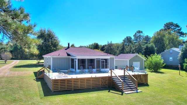 back of house with a sunroom, a lawn, and a deck