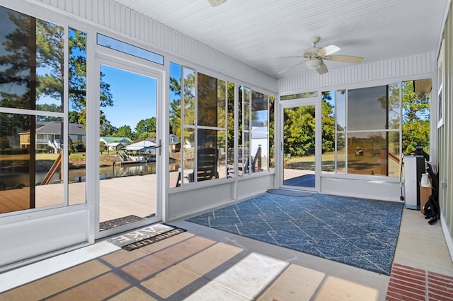 unfurnished sunroom with ceiling fan and plenty of natural light