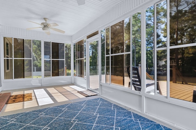 unfurnished sunroom with ceiling fan