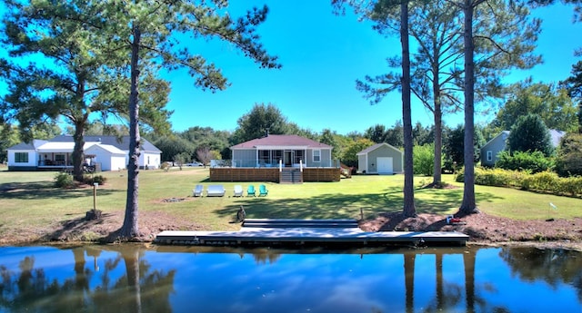 back of property with a lawn and a water view