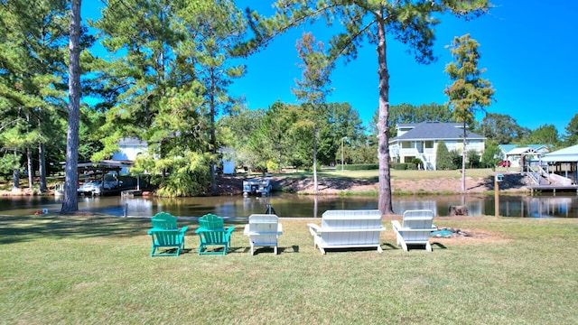 view of dock with a lawn and a water view