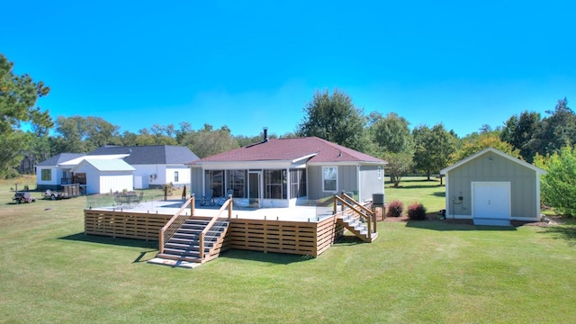 back of house with a lawn, a sunroom, a wooden deck, and a storage shed