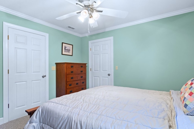 carpeted bedroom with a ceiling fan, visible vents, and crown molding