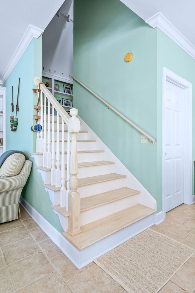 stairs featuring baseboards, ornamental molding, and tile patterned floors