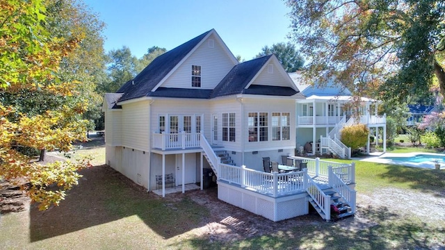 back of property featuring a lawn and stairs