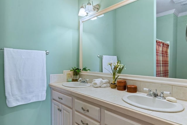 bathroom with ornamental molding, a sink, and double vanity