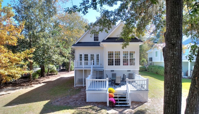 rear view of house with a deck, a lawn, and stairway