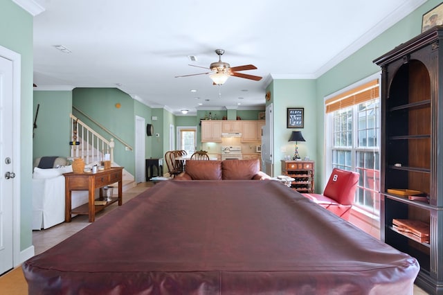 rec room with a healthy amount of sunlight, ceiling fan, and crown molding