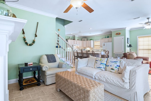 living area with a healthy amount of sunlight, stairs, visible vents, and crown molding