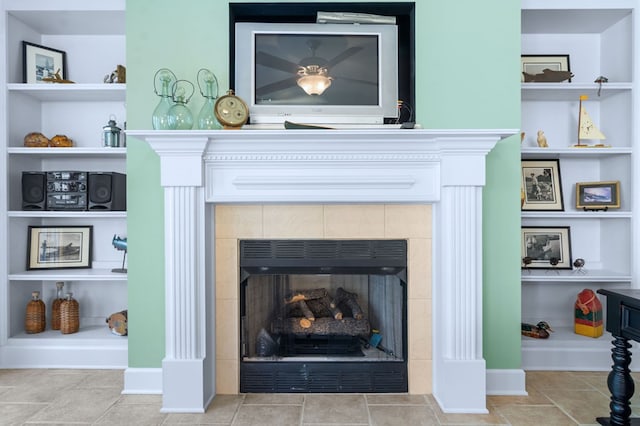 details featuring a tiled fireplace and built in features