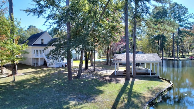 view of yard featuring stairway, a dock, a water view, and boat lift