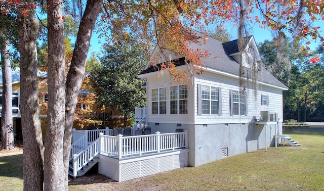 rear view of house with a lawn and a wooden deck